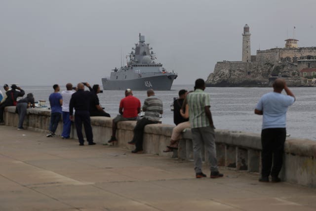 People watch a Russian navy frigate arrive at the port of Havana