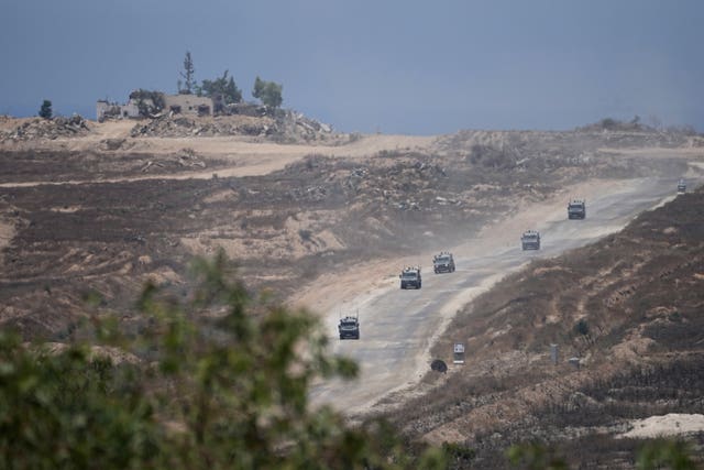 Israeli tanks move down the road in a column