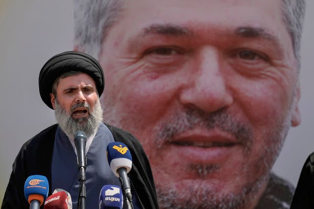 Senior Hezbollah leader Hashem Safieddine speaks before an image of the dead commander