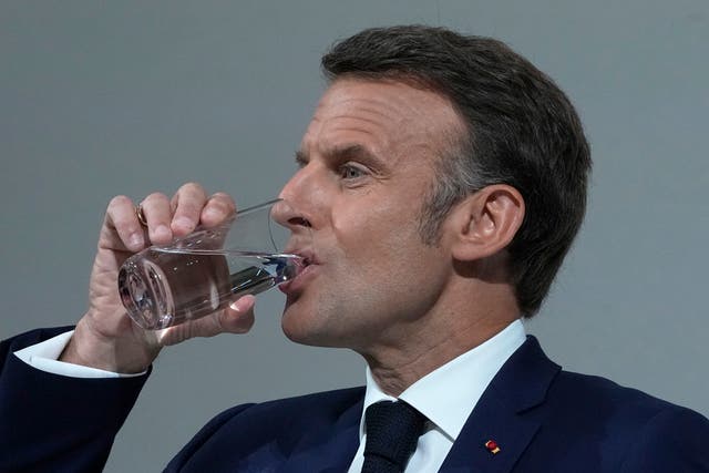 Emmanuel Macron drinks a glass of water