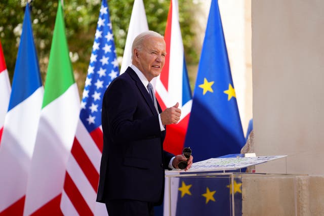 US President Joe Biden gives a thumbs-up as walks past various international flags as he arrives at the G7 Summit in Borgo Egnazia, southern Italy