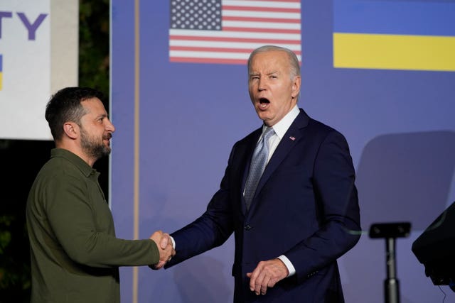 President Joe Biden answers no to a question about pardoning his son as he shakes hands with Ukrainian President Volodymyr Zelensky after signing a bilateral security agreement on the sidelines of the G7 in Savelletri, Italy