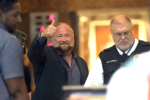 Alex Jones giving a thumbs-up as he goes through security at a Houston courthouse