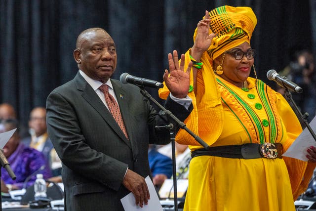Cyril Ramaphosa raises his hand as he is sworn is as a member of parliament, with Pemmy Majodina, an ANC politician