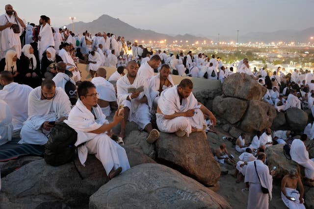 Muslim pilgrims sitting on Mount Arafat