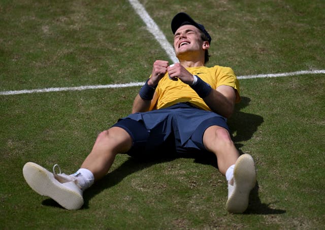 Jack Draper celebrates while lying on the grass after winning the Stuttgart Open