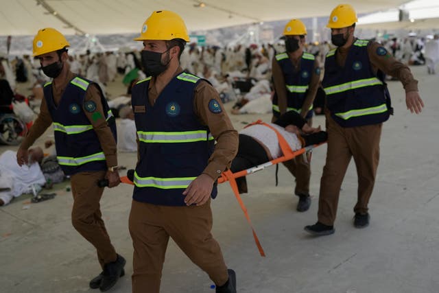 Paramedics carry a Muslim pilgrim for a medical check after he fell down due to a heat stroke at pillars, in Mina, near the holy city of Mecca, Saudi Arabia 