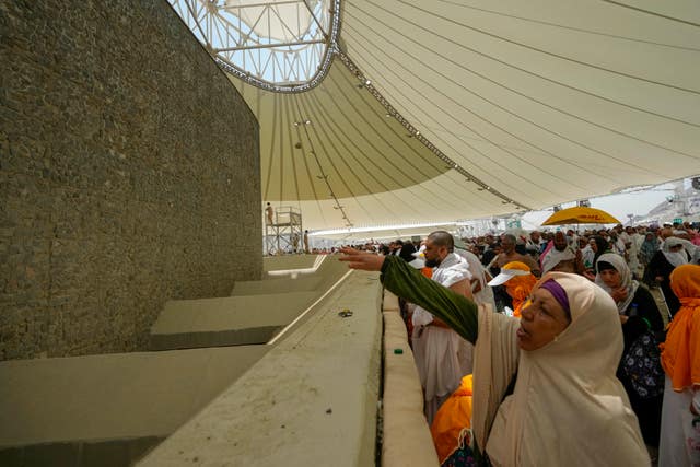Muslim pilgrims cast stones at pillars in the symbolic stoning of the devil, the last rite of the annual hajj, in Mina, near the holy city of Mecca, Saudi Arabia