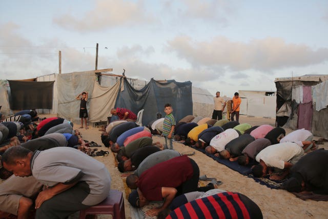Palestinians displaced by the Israeli air and ground offensive on the Gaza Strip offer Eid al-Adha prayers at a makeshift tent camp Khan Younis, Gaza 