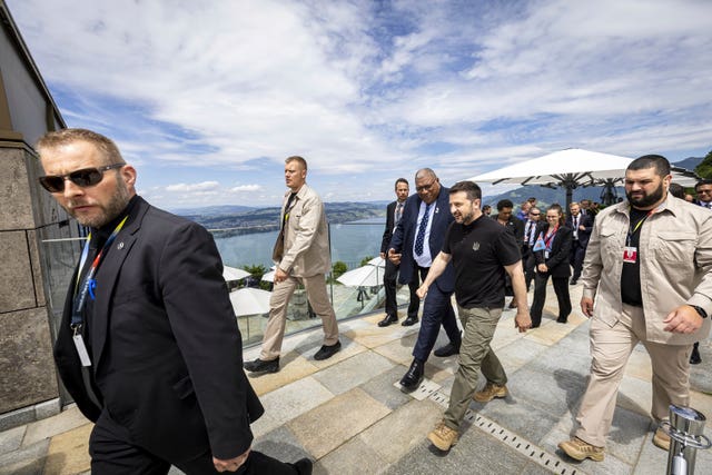 Ukrainian President Volodymyr Zelensky, centre, and Fiji’s President Wiliame Maivalili Katonivere walk during the Summit on peace in Ukraine, in Obburgen, Switzerland