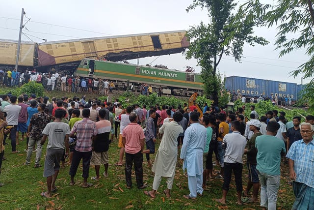 Onlookers watch as rescuers work after a cargo train rammed into Kanchanjunga Express, a passenger train, near New Jalpaiguri station, West Bengal state, India 