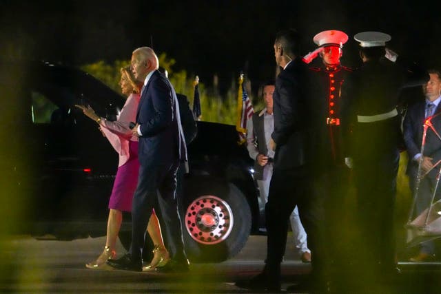 Mr Biden and his wife walk toward their motorcade after exiting the Marine One helicopter at Gordons Pond State Park near Rehoboth Beach
