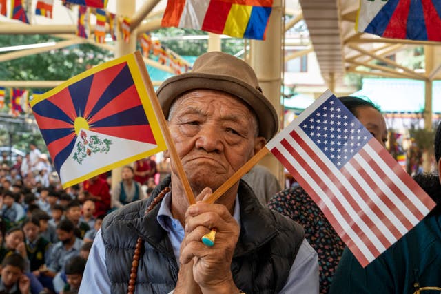 A man with US and Tibetan flags