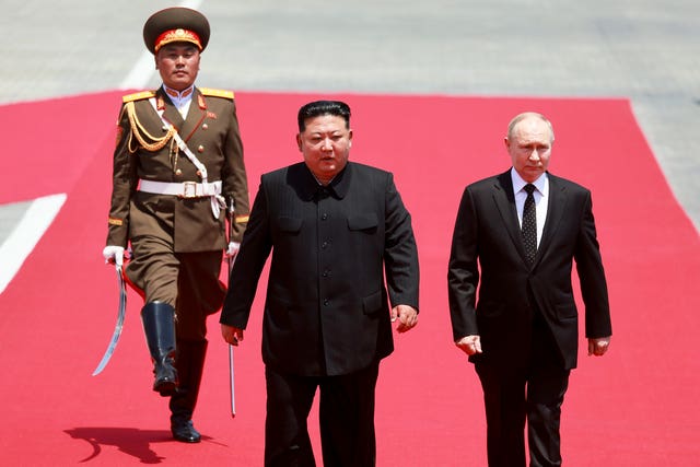 Mr Kim and Mr Putin march on a red carpet