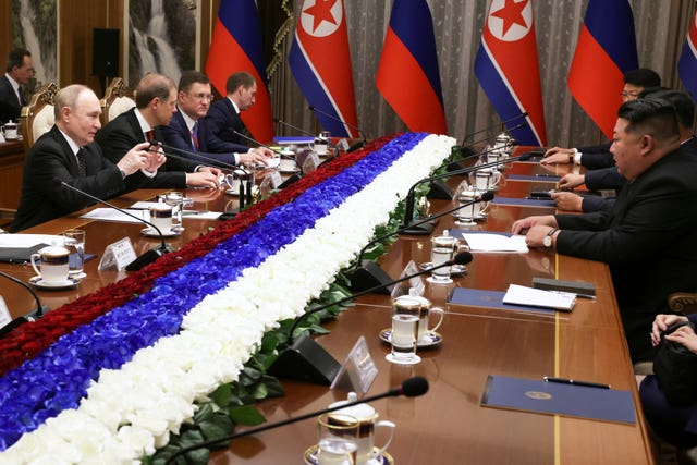 Mr Kim addresses Russian dignitaries across a table 