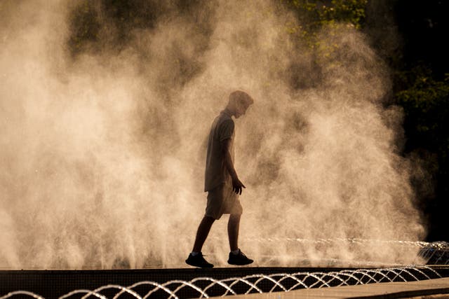 A man cools off in a fountain