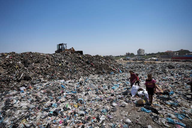 Palestinians sort through trash at a landfill in Nuseirat refugee camp, Gaza Strip