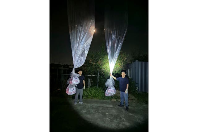 Two men holding large balloons