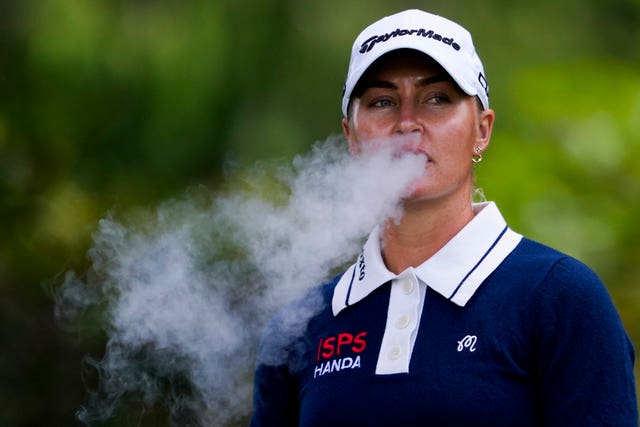 Golfer Charley Hull blows out smoke.