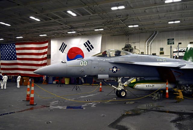 An F-18 fighter aircraft sits in the hangar of the Theodore Roosevelt (CVN 71), a nuclear-powered aircraft carrier, anchored in Busan Naval Base in Busan, South Korea