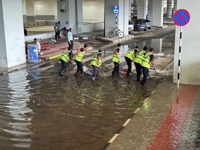 A crew removes water outside the Indira Gandhi International Airport after a heavy downpour 