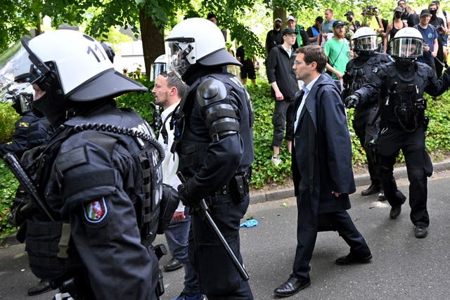 Participants of the AfD party conference are escorted by police