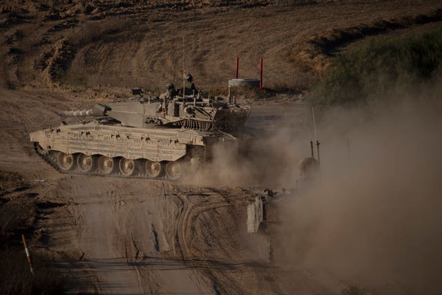 A tank moves through a dusty landscape