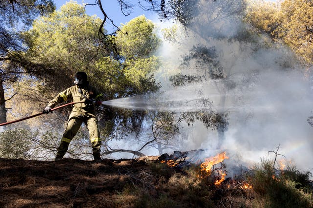  A firefighter struggles to extinguish a forest fire at Keratea area, southeast of Athens, Greece