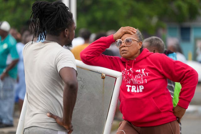 Sylvia Small, right, waits for police approval to enter the pier to check her boat’s damages due to Hurricane Beryl at the Bridgetown Fisheries in Barbados
