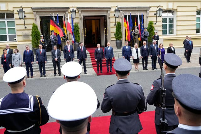 German Chancellor Olaf Scholz, centre left, and Polish Prime Minister Donald Tusk, centre right, review the guard of honour in Warsaw