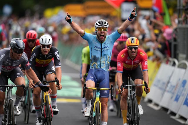 Mark Cavendish puts both hands in the air as he crosses the finish line after winning stage five of the Tour de France
