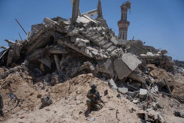 Israeli soldiers walk in the southern Gaza Strip, 