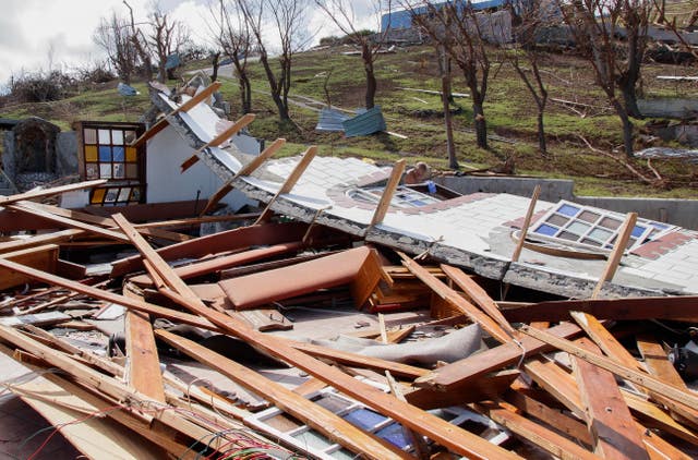 A man inspects a home destroyed by Hurricane Beryl