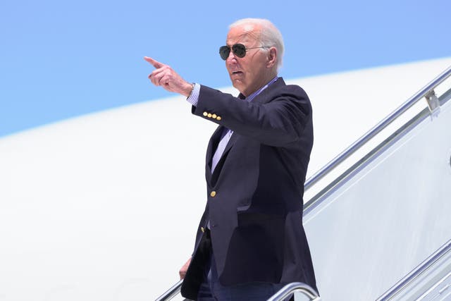 President Joe Biden points as he arrives on Air Force One at Dane County Regional Airport to attend a campaign rally in Madison, Wisconsin 