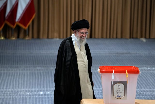 Iranian Supreme Leader Ayatollah Ali Khamenei walks towards the ballot box