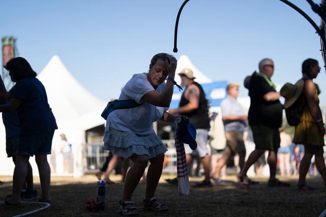 Corinne Dickey, of Portland, Ore., cools off under a mister