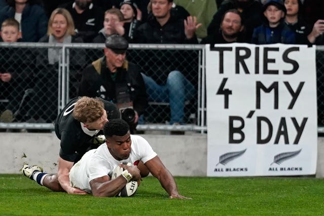 Immanuel Feyi-Waboso slides in to score a try in front of a banner reading 'Tries 4 my bday'