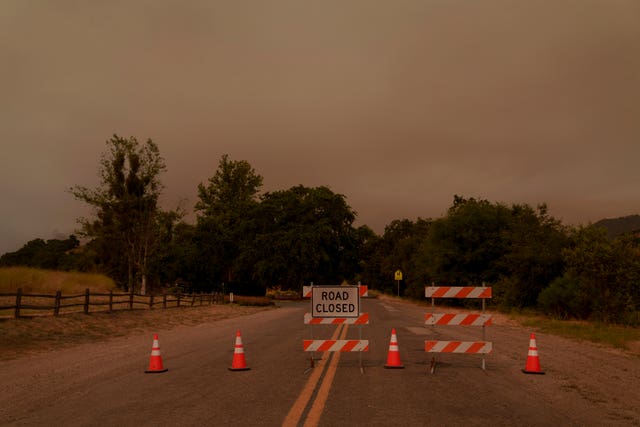 Signs and traffic cones block a road in California