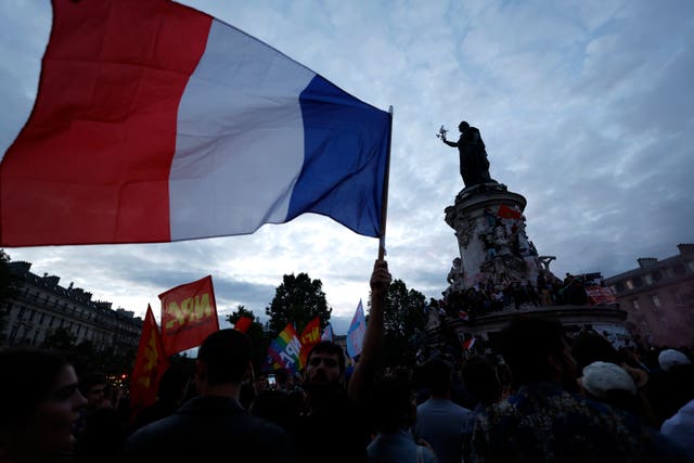 A French flag flown above a crowd in Paris