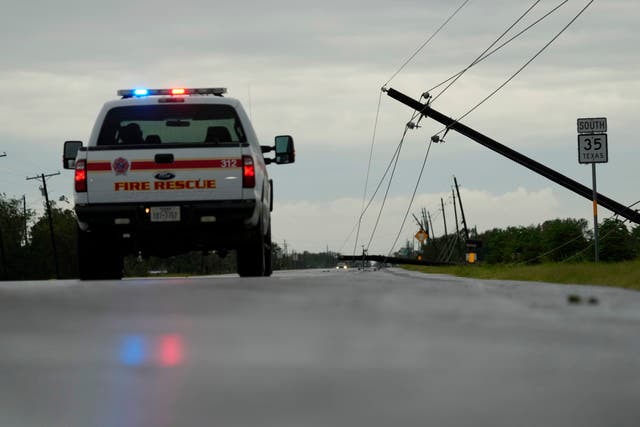 Camera is on the road and shows the rear of an emergency vehicle with a downed power line to the right