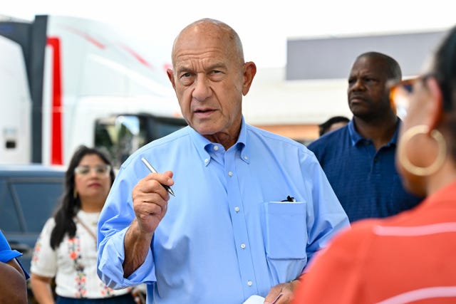 Man in blue shirt gives speech