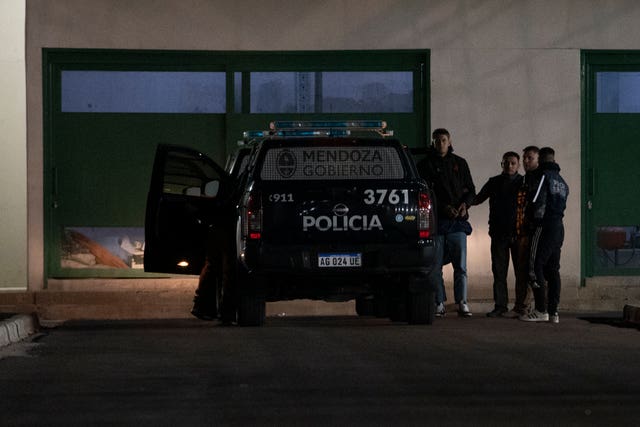 The players are escorted from a car by police