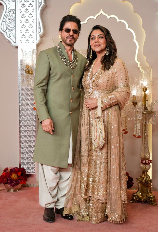 Bollywood actor Shah Rukh Khan in a green suits with his wife Gauri in beige 