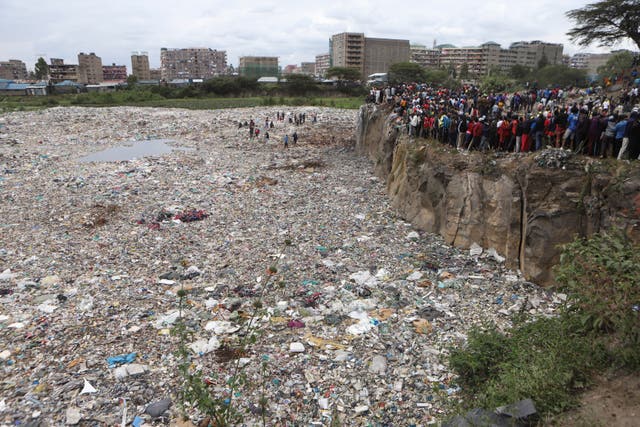 Crowds of people watch from the edge of a quarry 