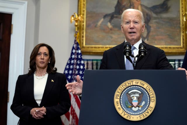 US President Joe Biden at lectern speaking in the Roosevelt Room of the White House as Vice President Kamala Harris listens