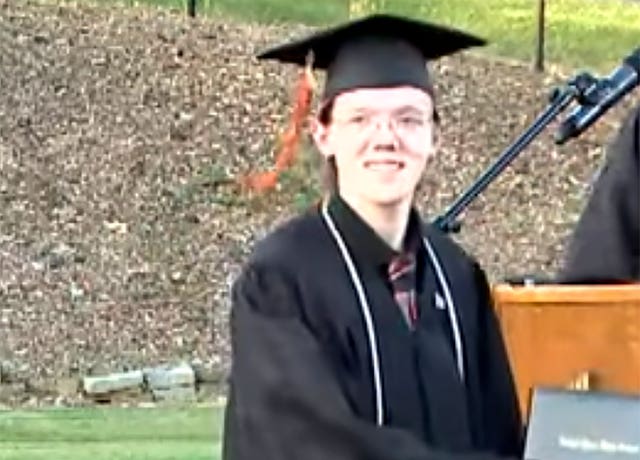 Head and shoulders photo of a young man wearing black graduation robes