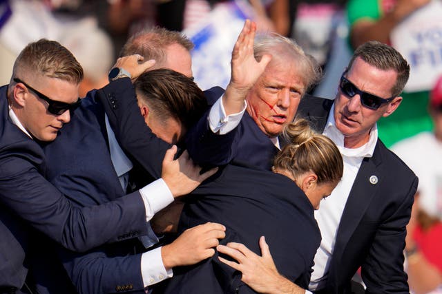 Mr Trump was helped off stage by US Secret Service agents 