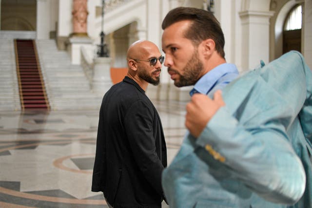 Andrew Tate, left, and his brother Tristan, who can be seen adjusting his suit jacket