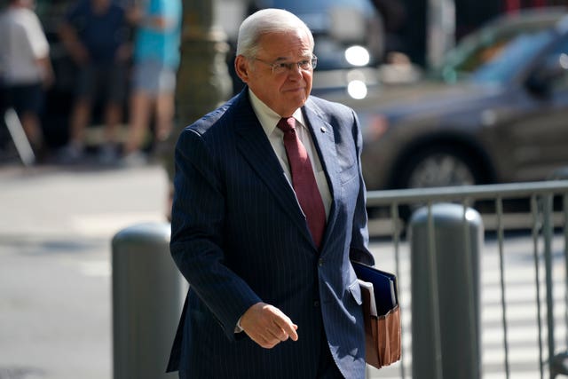 Bob Menendez walks into court in a suit and tie