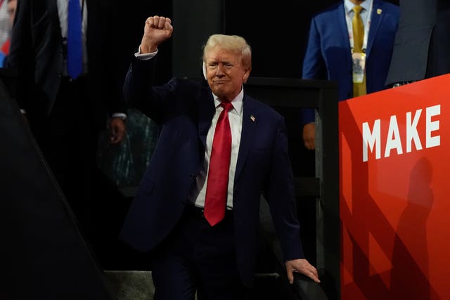 Donald Trump raises a fist above his head as he appears at the Republican National Convention